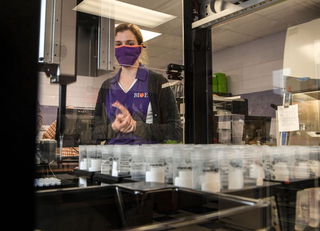 Delphine Dean, Professor of Bioengineering, watches as a robot processes a sample of saliva in the COVID-19 Clinical Diagnostics Lab at Clemson University.