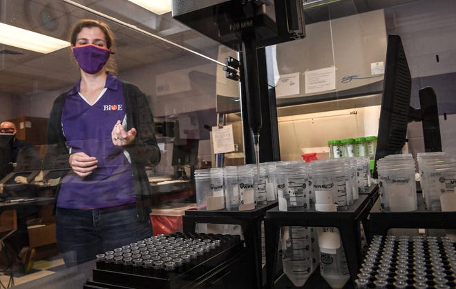Delphine Dean, Professor of Bioengineering, watches as a robot processes a sample of saliva in the COVID-19 Clinical Diagnostics Lab at Clemson University.