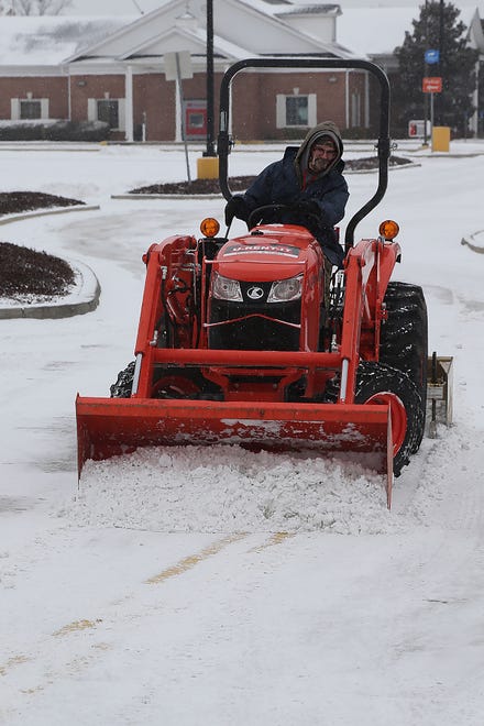 Jared Williamson with Greenscapes Landscaping uses a tractor with a front-end loader to clear the Walmart Neighborhood Market parking lot on U.S. 71 South, Sunday, Feb. 14, in Fort Smith after snow blanketed the area overnight. JAMIE MITCHELL/TIMES RECORD Caption Override