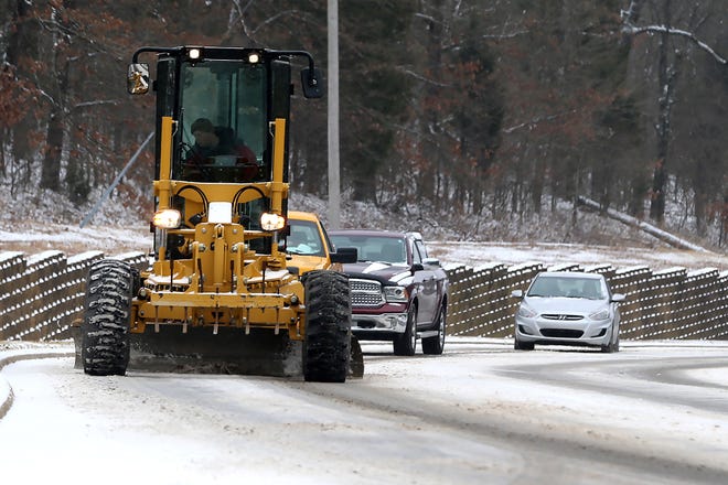 Vehicles follow a Fort Smith Street Department road grader up Old Greenwood Road, Sunday, Feb. 14, after snow blanketed the area overnight.