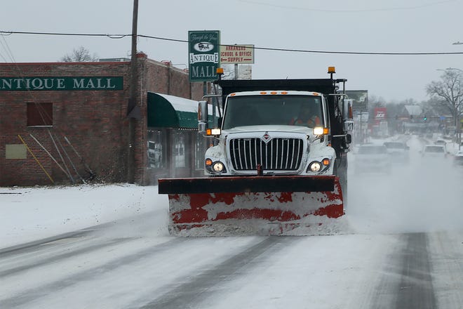 A plow truck with sander works along Rogers Avenue, Sunday, Feb. 14, in Fort Smith after snow blanketed the area overnight.