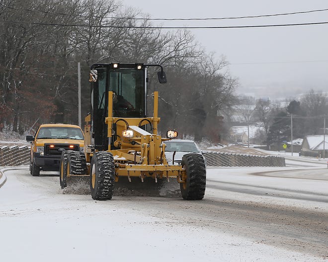A Fort Smith Street Department road crew work to keep Old Greenwood Rd clear near Cliff Drive, Monday, Feb. 15, after a heavy snow blanketed the area overnight.