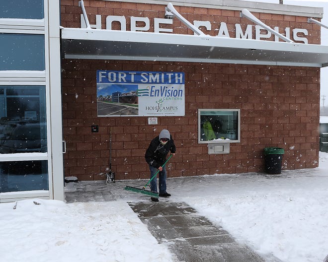 Brandon Becker sweeps snow from the Hope Campus front doors and sidewalks, Monday, Feb. 15, at the 301 S E St facility. Chris Joannides, MSW, executive director said that the homeless shelter provided sleeping arrangements for 128 people, Sunday, Feb. 14, after the outside tempature dropped to single digits and a heavy snow blanketed the area.