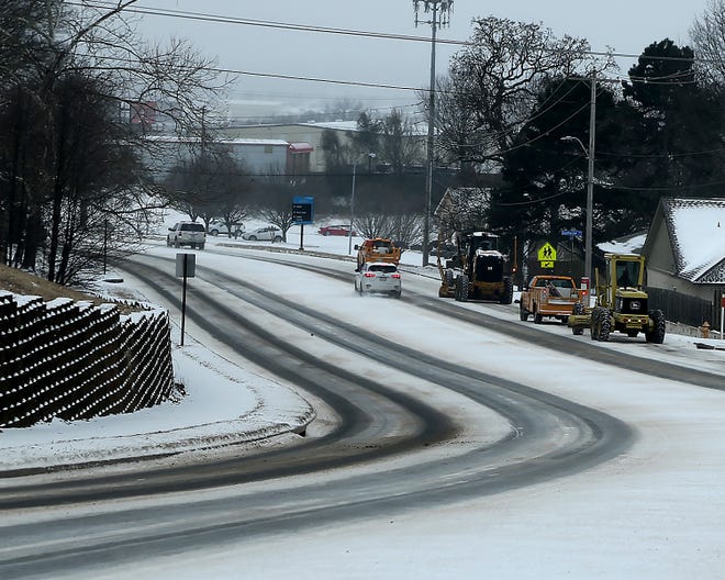 A Fort Smith Street Department crew work along Old Greenwood Road, Monday, Feb. 15, clearing lanes of snow.