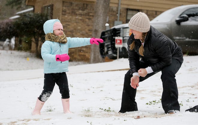 Snowfall greeted West Alabama residents Tuesday, Feb. 16, 2021. Four-year-old Sutton Costanzo plays with her mother, Hannah, as they make and throw snowballs in their front yard. [Staff Photo/Gary Cosby Jr.]