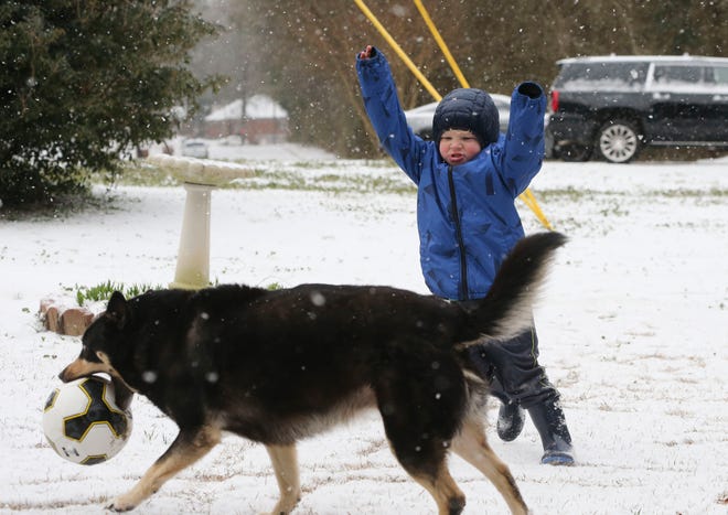 Snowfall greeted West Alabama residents Tuesday, Feb. 16, 2021. Grayson Hardin plays with his soccer ball and his dog Tink as they enjoy the rare snow day. [Staff Photo/Gary Cosby Jr.]