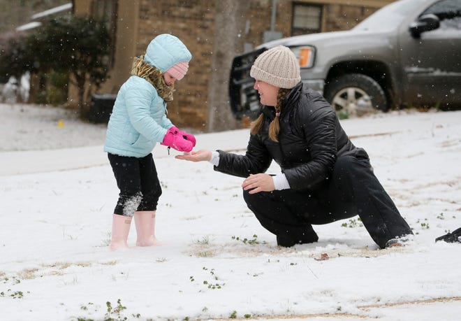 Snowfall greeted West Alabama residents Tuesday, Feb. 16, 2021. Four-year-old Sutton Costanzo plays with her mother, Hannah, as they make and throw snowballs in their front yard. [Staff Photo/Gary Cosby Jr.]
