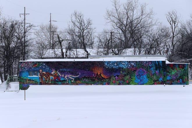A fantasy scene covers the side of a building on N 5th St in downtown Fort Smith.