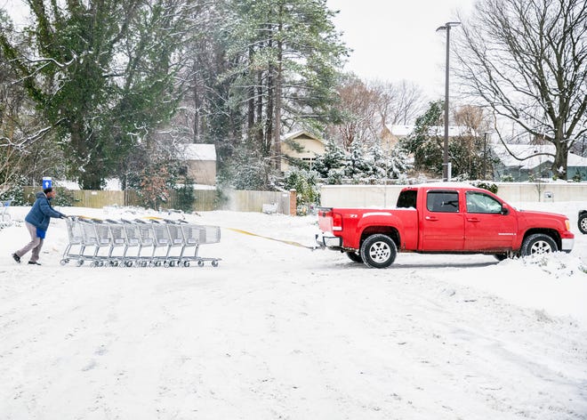 Jerry, who did not provide a last name, uses his truck to help a Kroger employee transport carts through the parking lot in Memphis, Tenn., on Thursday, Feb. 18, 2021.